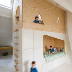 two children are playing on the bunk beds in this modern bedroom with white walls and wood flooring