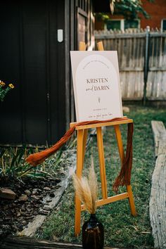 a wooden easel with a sign on it sitting in the middle of a yard