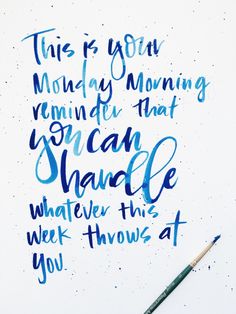 a quote written in blue ink on a white paper with a green brush next to it