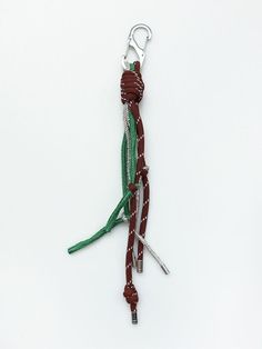 a pair of scissors are attached to a lanyard cord with green and white strips