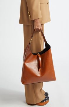 This slouchy calfskin-leather hobo bag blends a modern aesthetic with a '70s folk spirit, and of course has the Marcie line's signature slip-tassel closure. Bridge-tassel closure Shoulder strap Interior zip wall pocket Protective metal feet Leather Made in Italy Designer Handbags This brand has B Corp certification, representing business practices with emphasis on social and environmental performance, accountability and transparency This brand meets Nordstrom Responsible Brands criteria: brand a Fall Leather Hobo Bag, Cognac Bucket Bag With Handle Drop, Classic Cognac Hobo Bag For Shopping, Brown Calf Leather Bucket Bag For Work, Chic Brown Calf Leather Bucket Bag, Leather Hobo Bag For Work In Fall, Luxury Brown Hobo Bag For Shopping, Luxury Fall Hobo Bag For Everyday, Leather Bucket Hobo Bag