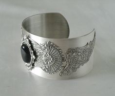 This beautiful silver plated cuff bracelet has a black onyx stone set on silver plated embellishments and silver plated gothic wings on the sides. Adjustable. Elegant Antique Silver Bracelets For Formal Occasions, Elegant Engraved Antique Silver Bracelets, Silver Metal Jewelry With Jewels, Elegant Metal Bracelets With Intricate Design, Antique Silver Metal Jewelry, Decorative Metal Bracelet Jewelry, Elegant Antique Silver Bracelets For Wedding, Antique Silver Elegant Wedding Bracelets, Elegant Antique Silver Wedding Bracelets