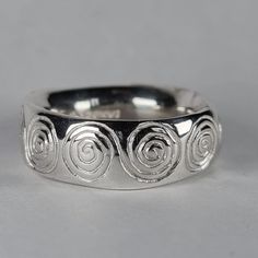 **Please note that we dispatch on Tuesdays unless special delivery express option is paid for** Sterling silver 'spirals' ring. Original design carved in wax then lost wax cast into solid sterling silver. This is a large and chunky ring, with a very rounded super smooth interior. It glides on like a silky glove. Item weighs approximately 12g in silver.  Band width 7.5mm Band thickness 3-3.5mm (uneven, and undulating thickness) First class recorded post included. Handmade Silver Band Ring, Cheap Handmade Silver Rings, Cheap Handmade Metal Rings, Chunky Silver Rings Men, Lost Wax Casting Rings Design, Spiral Sterling Silver Ring Stamped 925, Handmade Sterling Silver Spiral Rings, Silver Handmade Rings, Silver Spiral Sterling Silver Ring