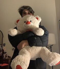 a man holding a large white teddy bear