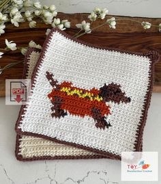 two crocheted coasters with dogs on them