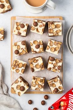 there are many pieces of dessert on the tray next to a cup of coffee and candy