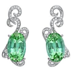 A distinguished pair of 11.66ct total oval Mint Green Tourmaline earrings for women, accented by a total of 0.23ct round brilliant diamonds. These 18K white gold Tourmaline diamond earrings are crafted by extremely skilled hands in the USA. Returns are accepted and paid by us within 7 days of delivery. Colorful alternatives for Green Tourmaline diamond earrings are Emerald earrings, Green Sapphire earrings, Tsavorite earrings. Tourmaline is the birthstone for October and it is also the celebrate Green Sapphire Earrings, Jewellery Trends, Vintage Drop Earrings, Indicolite Tourmaline, Diamond Earrings Studs Round, Tourmaline Earrings, Tourmaline Jewelry, White Gold Earrings, Emerald Earrings