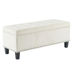 an upholstered bench with studded legs and a white leather cushion on top