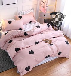 a pink bed with black hearts on it