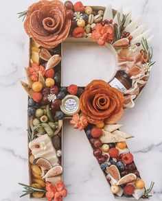 the letter r is made up of fruits, nuts, and other things to make it look like a flower