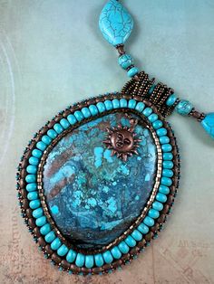 Pendant of magnesite turquoise framed with rondelles, hex beads and seed beads. The necklace is composed of magnesite turquoise as well. Artisan Beaded Turquoise Pendant Necklace, Beaded Howlite Turquoise Necklace With Round Beads, Artisan Beaded Turquoise Beads, Gems, And Cabochons, Artisan Turquoise Beaded Gems And Cabochons, Turquoise Beaded Pendant Necklace, Handmade Turquoise Howlite Beaded Necklaces, Turquoise Beaded Amulet Necklace, Handmade Artisan Turquoise Beads, Handmade Bohemian Turquoise Necklace