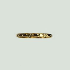 a gold wedding band with flowers on it