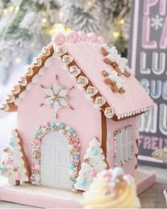 a pink gingerbread house with icing and decorations