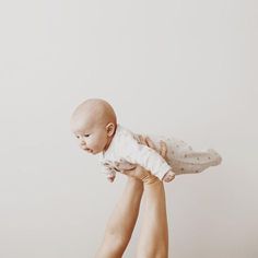 a woman holding a baby up in the air