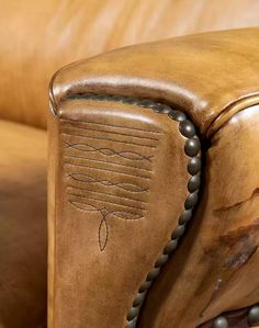 a close up of a leather chair with beaded trimmings and an arrow on the back