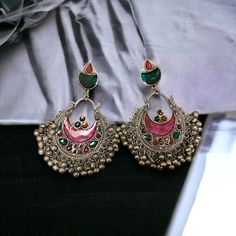 The Pink Gul Chandbali Earrings features intricate flower and peacock design on Oxidized Silver with multicolor crystals. The addition of ghungroos completes the look of this chandbali. Specifications Materials used: Oxidized Silver, Meenakari, Ghungroos At Romikas, we pride ourselves on the craftsmanship and high quality of our jewelry, designed to enhance your natural beauty. Please contact us with any questions. Multicolor Chandbali Earrings With Intricate Design, Bohemian Kundan Chandbalis With Intricate Design, Multicolor Chandbali Jhumkas With Intricate Design, Traditional Multicolor Oxidized Earrings, Traditional Multicolor Chandbalis With Latkans, Ornate Chandbalis For Diwali, Multicolor Chandbali Earrings For Festival, Multicolor Meenakari Chandbali Danglers, Ornate Meenakari Chandbalis For Festivals