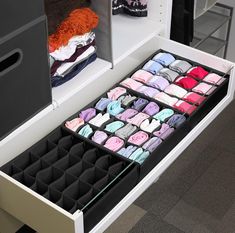 an organized drawer is shown with folded shirts and socks in the bins on the bottom shelf