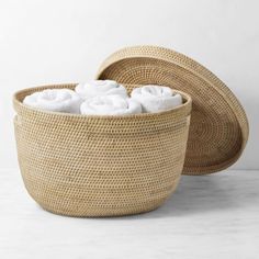 two woven baskets with white towels in them