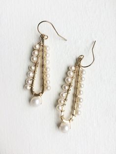 A celebration of pearls in a modern style. A larger pearl dangles from the bottom while smaller pearls line the long teardrop. + Pearls. 14K Gold Filled Ear Wire. 14K Gold Plated Teardrop. + Earrings measure 2.5 inches (6.3 cm) in length. + Earrings take 1 business day to make. + Your jewelry will come in a jewelry box, tied with a ribbon. ➤➤ Have a question about this product, reach out to me here ➙ https://www.etsy.com/conversations/new?with_id=9057464&referring_id=5772224&referring_ty Teardrop Pearl Drop Chandelier Earrings For Party, Teardrop Pearl Drop Chandelier Earrings, Teardrop Chandelier Earrings With Pearl Drop, Formal Teardrop Linear Earrings With Pearl Charm, Elegant Teardrop Pearl Earrings With Dangling Beads, Formal Pearl Chandelier Earrings With Pearl Drop, Elegant Teardrop Jewelry With Dangling Beads, Pearl White Dangle Chandelier Earrings With Pearl Drop, Pearl Drop Chandelier Earrings