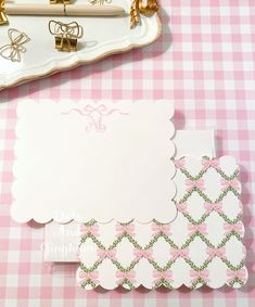 pink and white checkered table cloth with personalized notepads, mirror and purse