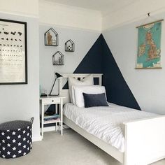 a bed room with a neatly made bed next to a night stand and pictures on the wall