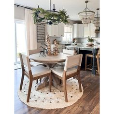 a dining room table surrounded by chairs with christmas decorations on the top and around it