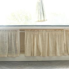 a window sill with curtains hanging over it