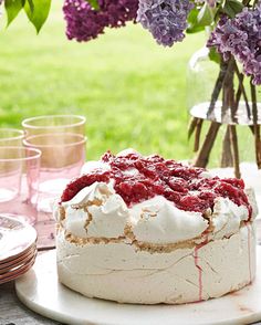 a cake sitting on top of a table covered in frosting and raspberries