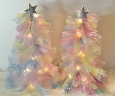 two plastic christmas trees with lights on them