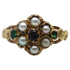 Here at Kirsten’s Corner, we have a sweet spot for these early Victorian flower rings. This 15k gold ring is reminiscent of a Forget-Me-Not flower, a popular motif in the Victorian era. The pearl flower petals in the ring represent tears and capture the romance in our hearts. A central garnet sits delicately amidst a lacy background, while two Old Emerald Cut emeralds add a pop of green to each side of the flower. Each stone is prong set into an early Victorian setting that was traditional for these types of rings. Along the sides is scrolling foliate, hand detailed to look like leaves. A lovely engraving goes all the way around the band of the ring, even detailing the edges of the band. Circa 1850, this is a very old ring that conveys sentimentality and everlasting love. The garnet measur 16th Century Jewelry, Antique Engagement Rings Victorian, Antique Emerald Engagement Ring, Victorian Wedding Ring, Green Engagement Rings, Antique Rings Victorian, Victorian Style Rings, Avon Rings, Art Nouveau Ring