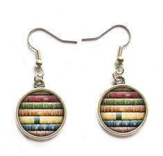 a pair of earrings with colorful books on them