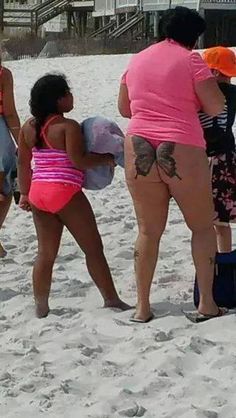 three girls in bathing suits on the beach with their backs to each other and one girl holding a suitcase