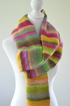 a white mannequin wearing a multicolored scarf