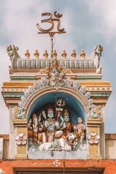 an ornately decorated entrance to a temple with statues on the front and side walls