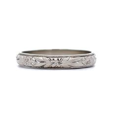 an antique wedding band with flowers and leaves on the side, in white gold or silver