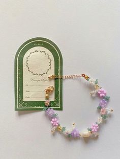 a bracelet with pink, green and white beads is next to a card that says happy mother's day