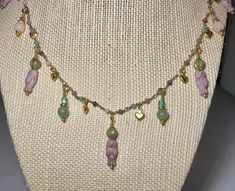 This dainty necklace is a unique Czech glass owl beaded charm necklace. The owls and dangle charms are in shades of purple, green, aqua, and blue, and are interspersed with tiny gold hearts. The chain is made up of purple, pink, green, and aqua beads. The necklace is adjustable from 16 to 18 inches. It is a must for owl lovers! Handmade Spiritual Dangle Charm Necklaces, Handmade Adjustable Whimsical Charm Necklace, Whimsical Handmade Dangle Necklaces, Handmade Dangle Charm Necklaces, Whimsical Czech Glass Necklaces For Gifts, Whimsical Czech Glass Necklaces As Gifts, Whimsical Handmade Dangle Necklace, Whimsical Czech Glass Necklace For Gift, Whimsical Adjustable Dangle Charm Necklaces