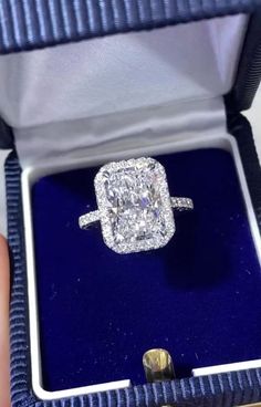 a cushion cut diamond ring in a blue velvet box