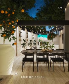 an outdoor dining area is lit up at night with oranges hanging from the ceiling