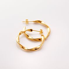 Our Ripple Hoop Earrings are inspired by the ripple effect that a pebble can cause in the ocean - these hoops stand as a reminder that you can have a ripple effect on the world with even the smallest action. Materials & Warranty Material: Real 18 karat gold plating on pure stainless steel Hypoallergenic | Sensitive Skin-Friendly Warranty: Lifetime Warranty against all rust or tarnish Packaging: Nominal Velvet Drawstring Pouch Earrings cannot be returned or exchanged due to hygienic safety Modern Twist Hypoallergenic Hoop Earrings As Gift, Modern Twist Hypoallergenic Hoop Earrings For Gifts, Modern Twist Huggie Earrings As Gift, Modern Twist Huggie Earrings For Gifts, Modern Twist Round Earrings For Everyday, Modern Twist Nickel Free Hoop Earrings, Modern Twist Hoop Earrings As Gift With Polished Finish, Modern Twist Nickel-free Hoop Earrings, Modern Twisted Earrings As A Gift