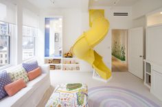 a living room filled with furniture and a yellow spiral staircase in the middle of it