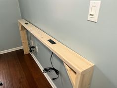 an electrical outlet in the corner of a room with wood flooring and blue walls