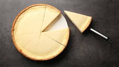 a piece of cheese pie with one slice cut out and the other half on a black surface