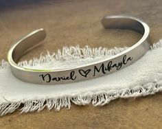 This listing features ONE stainless steel silver, gold, or rose gold cuff bracelet for your daughter or daughter in law.  The outside of the bracelet will come with the bride and groom's names separated with a heart symbol, or a monogram in the script font shown, along with a date on one end and a heart or Love infinity symbol on the other end. The inside of the bracelet will come with a message, personalized if desired.  -->Today God blessed my son with a wife, and me a daughter and friend for Personalized Stainless Steel Jewelry With Custom Text, Customized Silver Jewelry For Bridesmaid Gift, Silver Bangle For Valentine's Day Gift, Personalized Wedding Bangle Jewelry, Silver Stainless Steel Bangle For Anniversary, Silver Stainless Steel Anniversary Bangle, Minimalist Stainless Steel Bangle For Anniversary, Minimalist Stainless Steel Anniversary Bangle, Custom Text Stainless Steel Jewelry For Gift