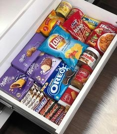 an open drawer filled with snacks and condiments on top of a countertop