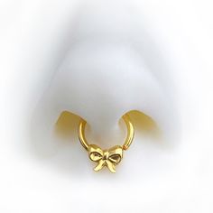 a gold nose ring with a bow on it