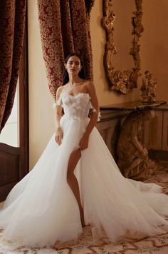 a woman in a wedding dress posing for the camera