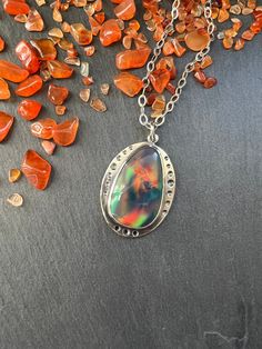 "This stone is a man made aurora borealis opal.  It has very interesting multicolored color play that reminds me of a galaxy inside.   The pendant is made with sterling silver and the stone is set in a bezel setting. NOTE:  As with all opal, this is a soft stone so care will need to be taken to not scratch or damage it.  Always remove your jewelry prior to washing and showering.  Jewelry should always be the last thing you put on after applying makeup, perfume, hairspray, etc.  Never wear soft stone jewelry while working out, or to bed, as this my cause unnecessary wear and tear and my damage the stone. Total length of the pendant is 38mm (approximately 1.5\"). Width is 28mm (approximately 1.13\"). When purchasing you have the option to purchase the pendant only or with your choice of chai Mystical Iridescent Sterling Silver Jewelry, Unique Iridescent Nickel-free Necklace, Unique Iridescent Cabochon Necklaces, Iridescent Mystical Pendant Jewelry, Mystical Iridescent Pendant Jewelry, Mystical Iridescent Pendant Necklace, Celestial Gemstone Jewelry Collectible, Iridescent Nickel-free Spiritual Necklaces, Handmade Iridescent Opal Necklaces