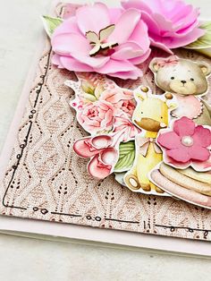 a close up of a card with flowers and a teddy bear on the front cover