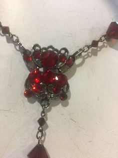 This is a beautiful red long necklace that can be adjusted and used multi ways. Wrap it around your neck for a choker look or adjust it to fit however you wish. Ruby red crystal beads plated in black . Cross has crystals on both sides. Red Gothic Jewelry For Party, Red Gothic Necklace For Formal Occasions, Red Metal Choker For Party, Red Choker Necklaces For Formal Occasions, Red Choker Necklace For Formal Occasions, Formal Red Choker Necklaces, Formal Red Choker Necklace, Red Ruby Choker Necklace, Red Metal Evening Jewelry